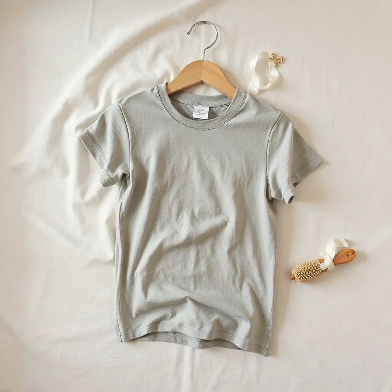 Soft durable t-shirt folded on a light surface with visible knit texture and subtle care items